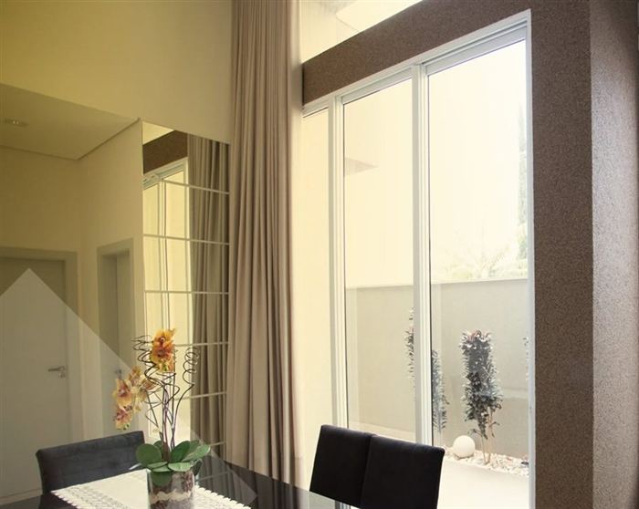 Sala de jantar com parede espelhada e revestimento