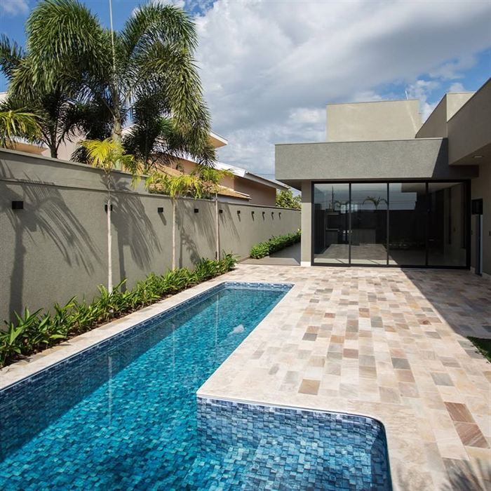Piscina com deck em pedra e área de lazer