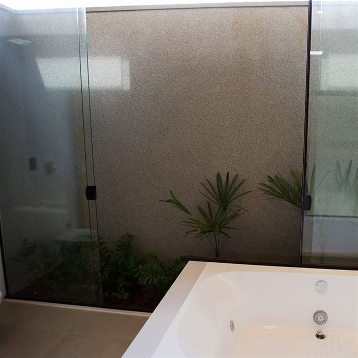 Banheiro com parede em revestimento texturizado e jardim interno